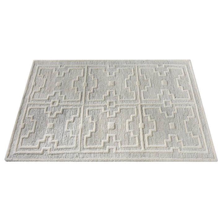 Chattan handwoven New Zealand wool rug with raised ivory diamonds on stone grey, in a living room
