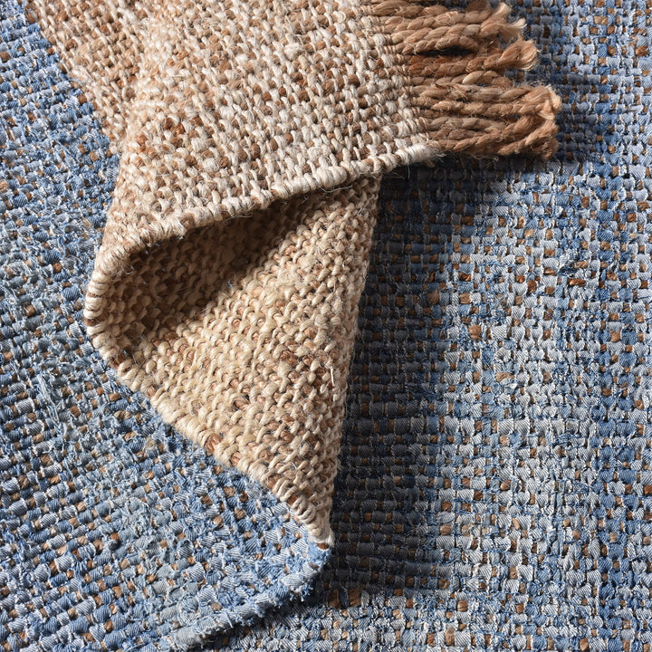 Nahar flatweave hemp and denim rug with a denim-blue stripe on natural hemp, in a living room