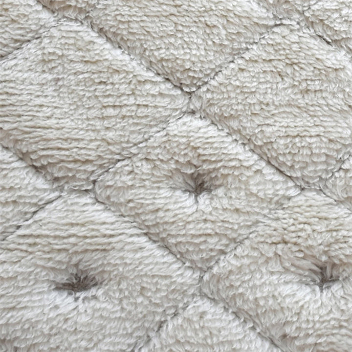 Til handwoven New Zealand wool flatweave rug with an ivory diamond lattice and dots, in a living room