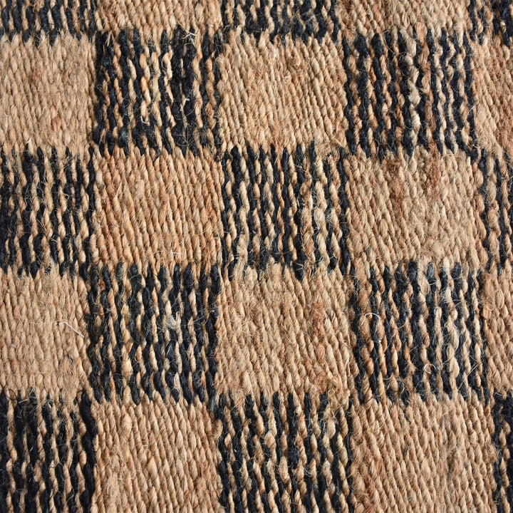 Chessboard handwoven jute rug with natural and charcoal checkerboard, in a living room