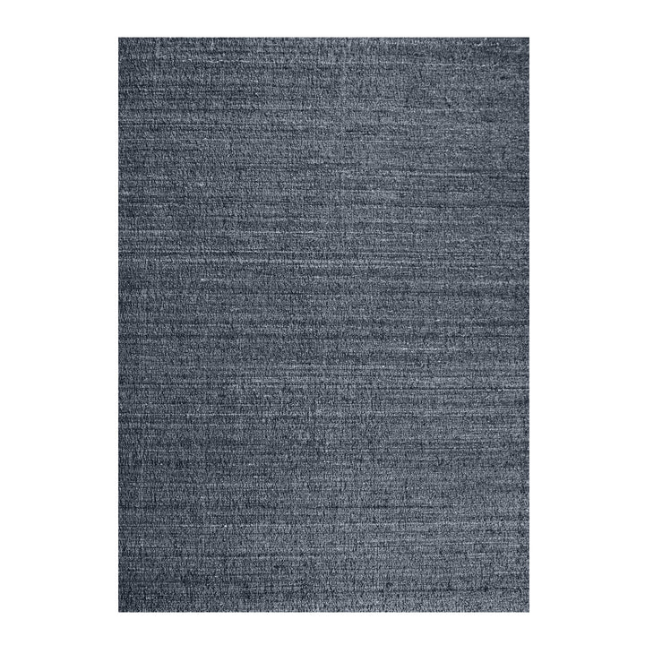 Saada handwoven flat wool rug in solid stone beige with charcoal, in a living room