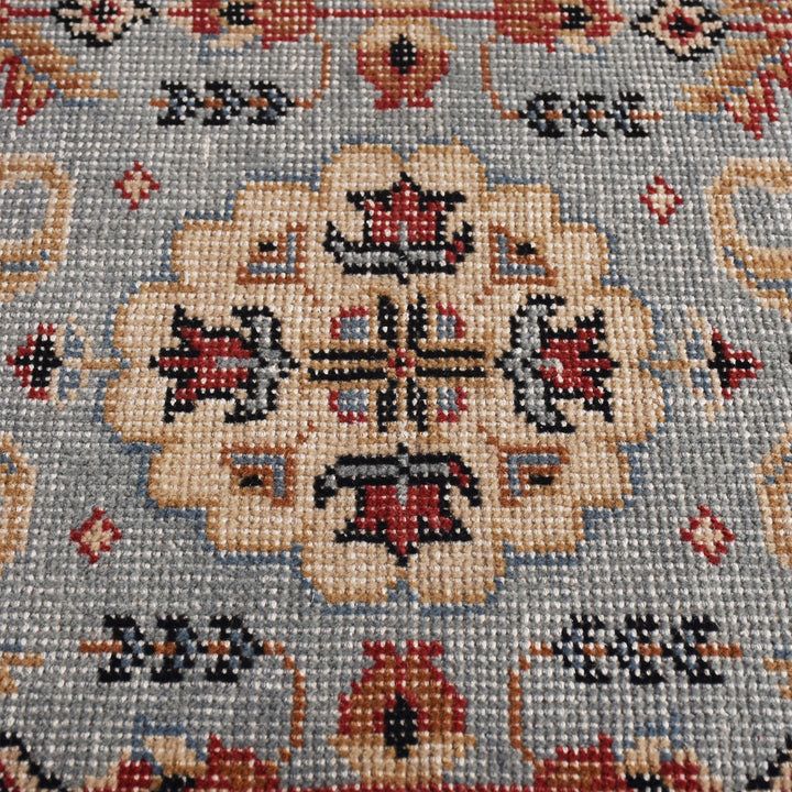 Manor hand-knotted slate grey wool rug with rust and red medallions, in a dining room