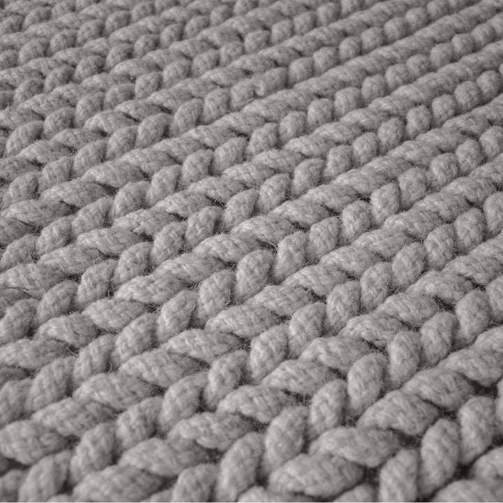 Dor handwoven chunky wool rug in charcoal, woven in thick cords, in a living room