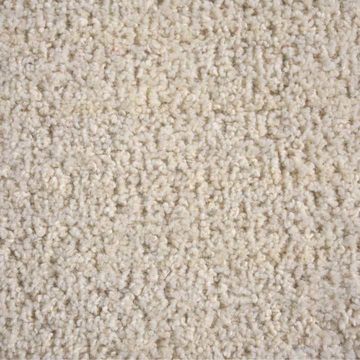 Gol handwoven wool rug in plain cream with a soft cut pile and a curved edge, in a nursery