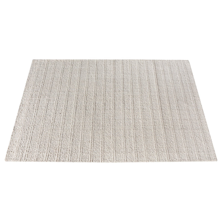 Oon handwoven ribbed wool rug in undyed oatmeal with horizontal ribs, under a coffee table