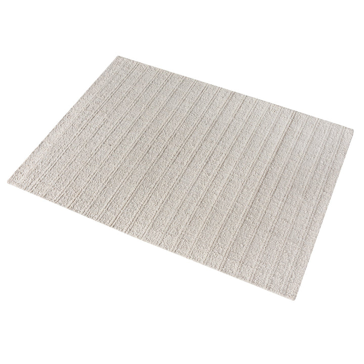 Oon handwoven ribbed wool rug in undyed oatmeal with horizontal ribs, under a coffee table