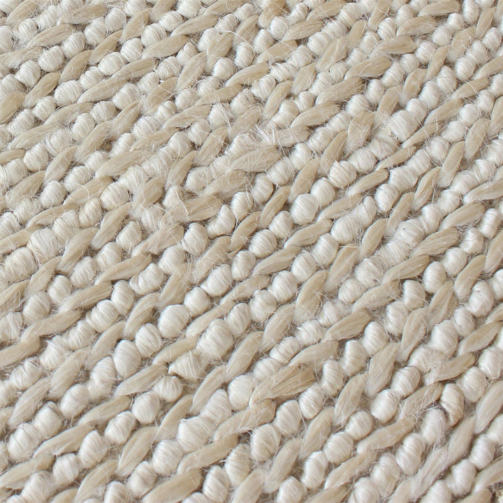 Kai handwoven hemp rug in natural with a sage cast and a tight chunky weave, in a living room