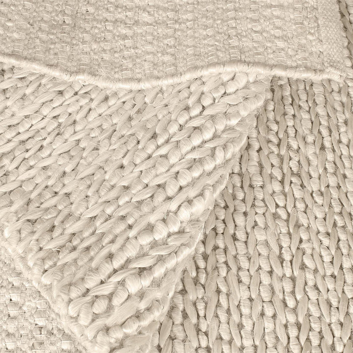 Kai handwoven hemp rug in natural with a sage cast and a tight chunky weave, in a living room