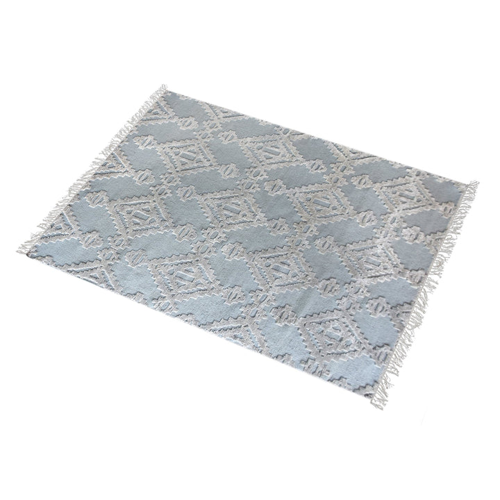 Mor hand-knotted wool rug with ivory raised diamonds on duck egg blue, in a bedroom