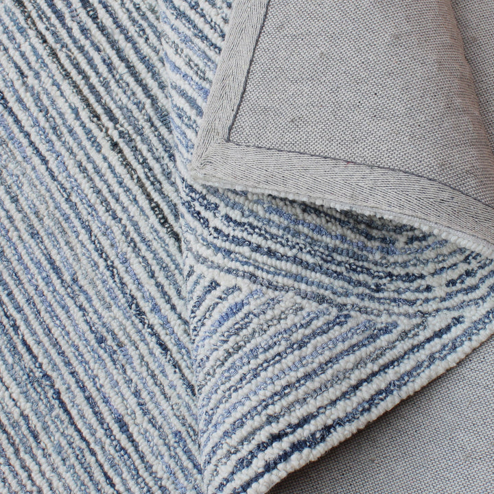Estuary handwoven wool and denim rug with denim blue contour lines on ivory, in a dining room