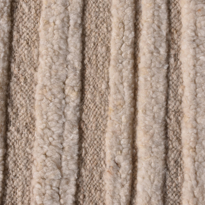 Pankti hand-knotted NZ wool rug in cream and oat with carved vertical stripes, in a dining room