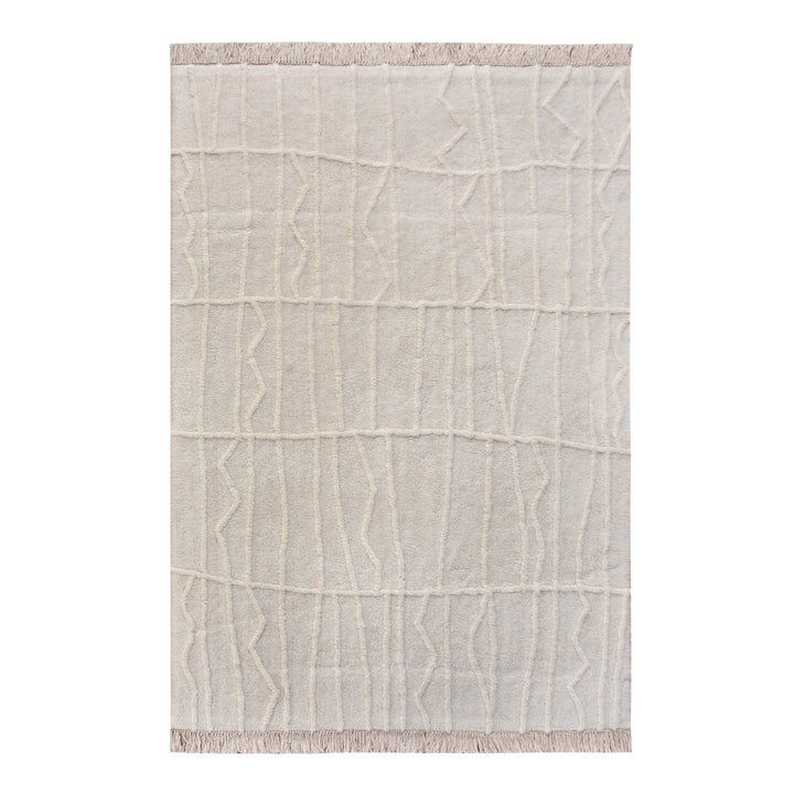 Swell tufted ivory New Zealand wool rug with carved waves and fringe, in a living room