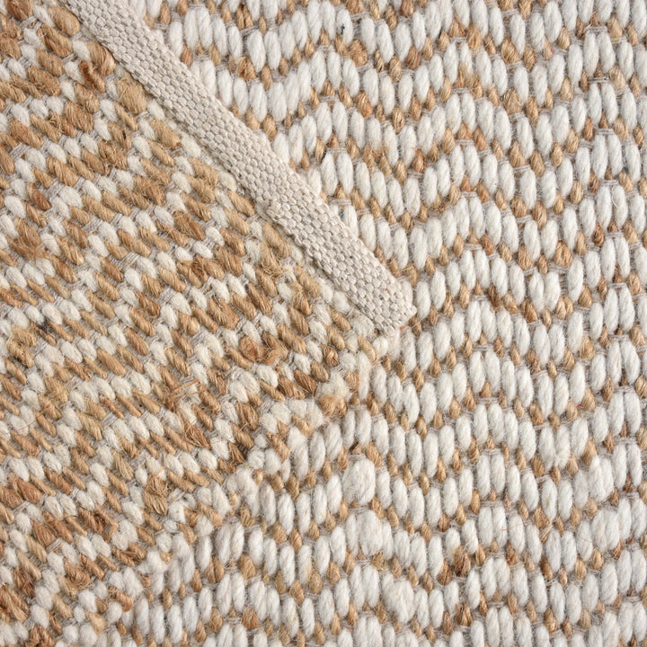 Chevron handwoven cream wool and jute rug with a herringbone chevron weave, in a living room
