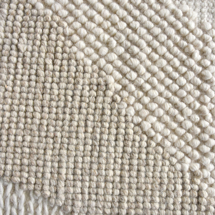 Pahad handwoven greige wool rug with carved contour waves, in a living room