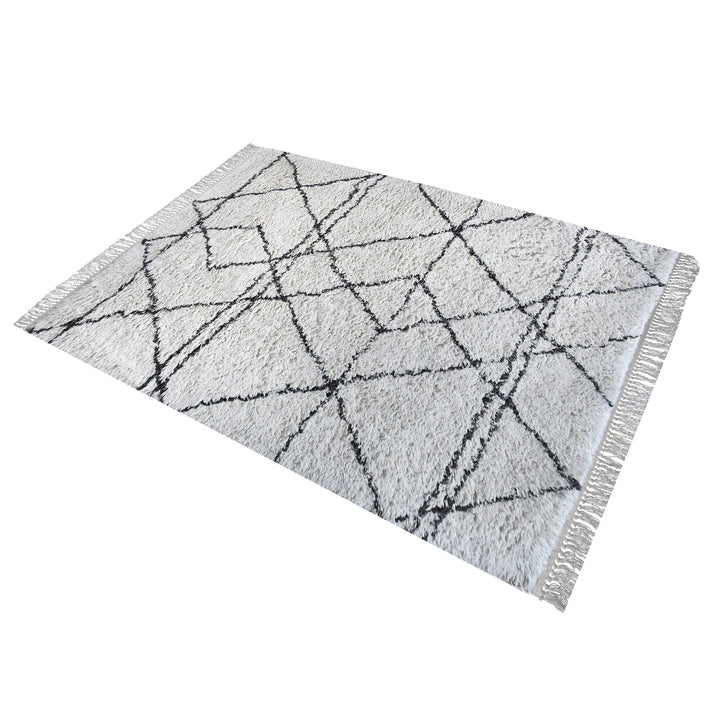 Lipi tufted cotton shag rug in ivory with a bold black lattice, in a bedroom