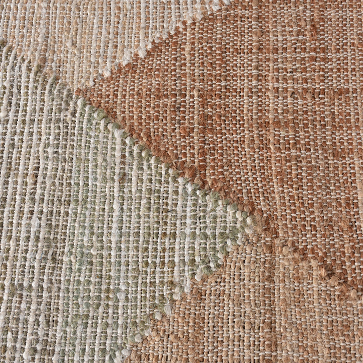 Patang handwoven jute flatweave rug with large blush, tan and grey diamonds, in a bedroom