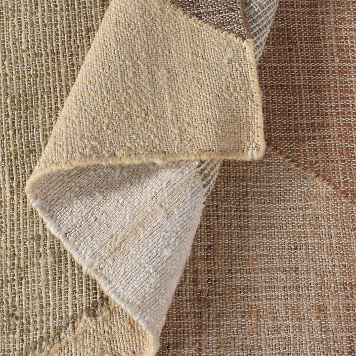 Patang handwoven jute flatweave rug with large blush, tan and grey diamonds, in a bedroom