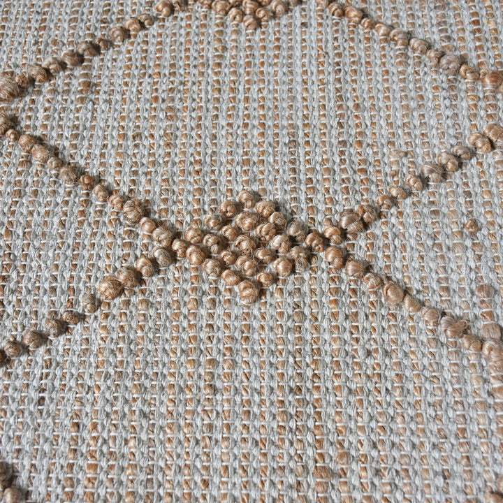 Driftwood handwoven jute rug with natural and grey diamond lattice, in a living room