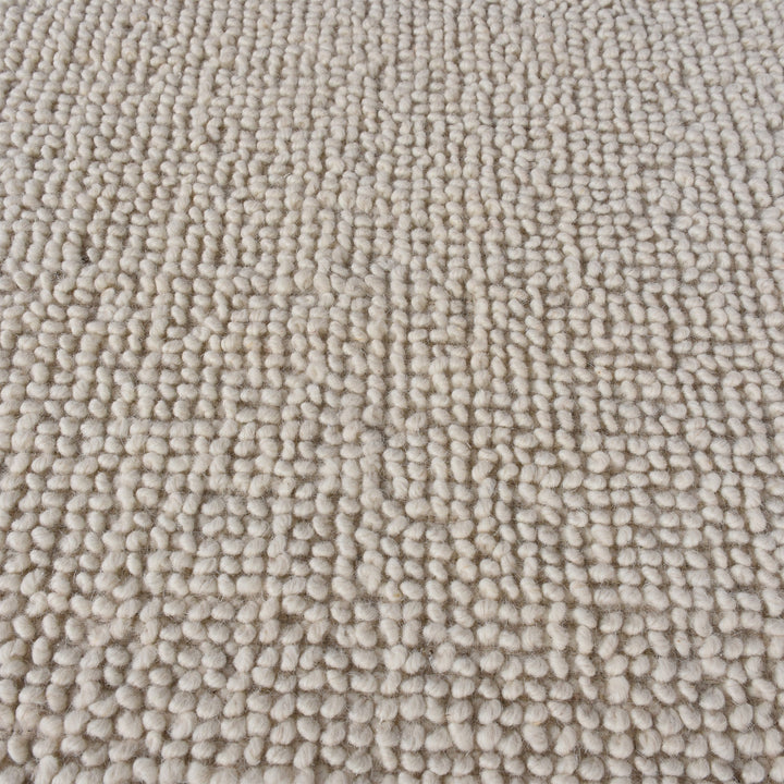 Lakeer handwoven ridged wool rug in oatmeal, tone on tone, in a bedroom