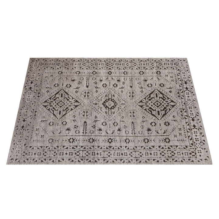 Inkwell hand-knotted ivory wool rug with a faded black tribal medallion, in a living room