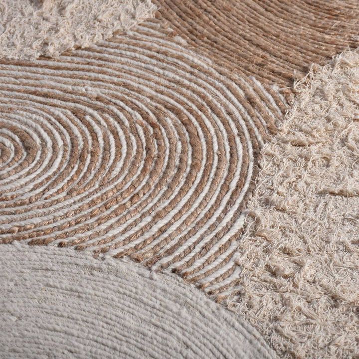 Boond handwoven wool, hemp and cotton rug with overlapping ivory and tan circles, in a bedroom
