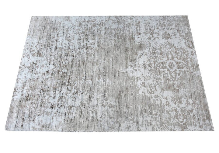 Parchhai handwoven viscose rug with an erased medallion on pale silver beige, in a living room