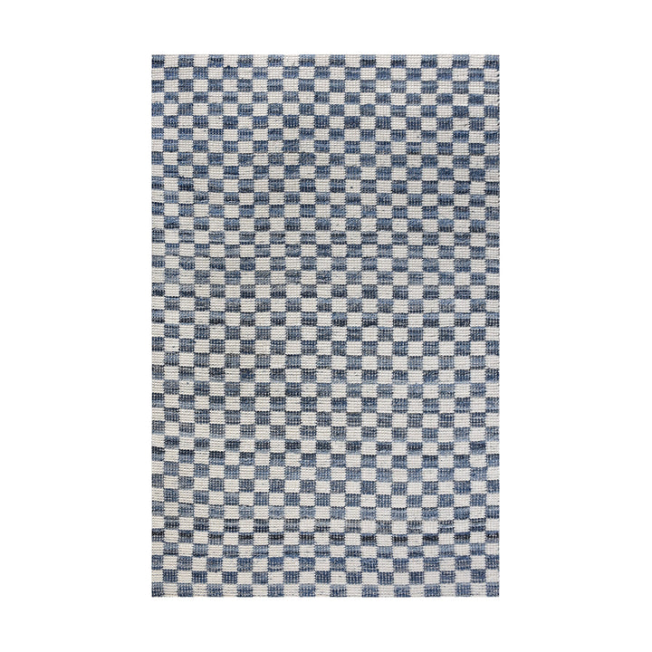 Taash handwoven denim and cotton rug with a navy and ivory checkerboard, in a living room