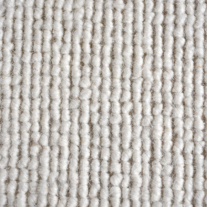 Mist handwoven pale stone wool rug with a chunky looped weave, in a living room