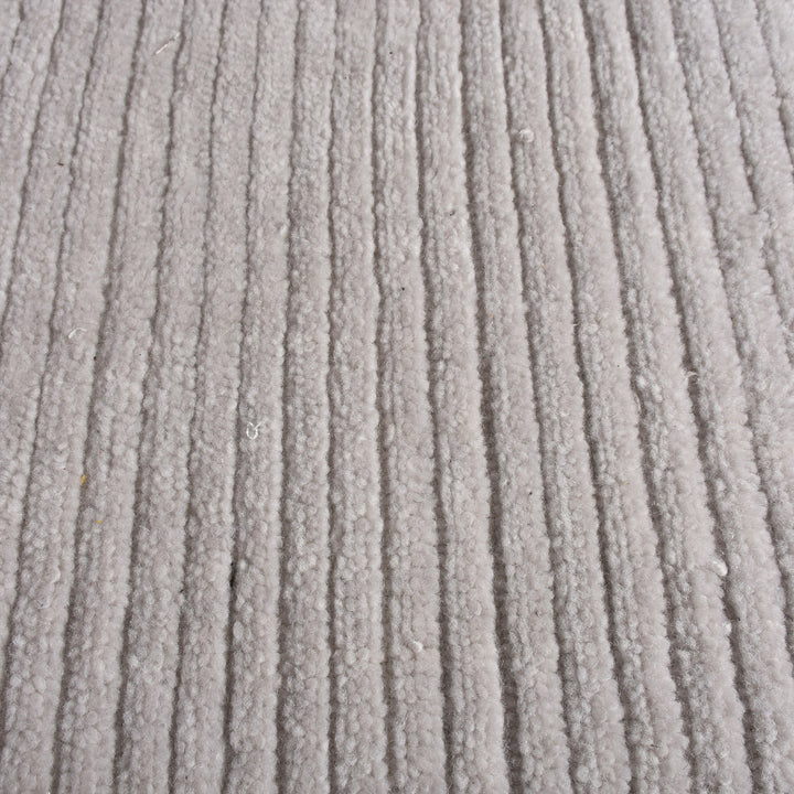 Megh handwoven NZ wool rug in light grey with wide ribbed vertical bands, in a living room