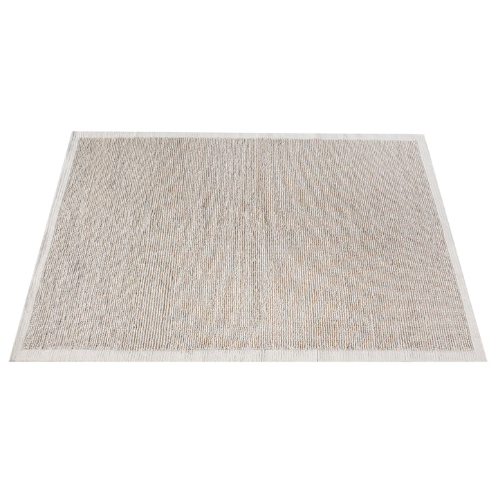 Shant handwoven flatweave wool rug in natural ivory with fine ribs and fringe, beside a bed