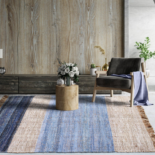 Nahar flatweave hemp and denim rug with a denim-blue stripe on natural hemp, in a living room