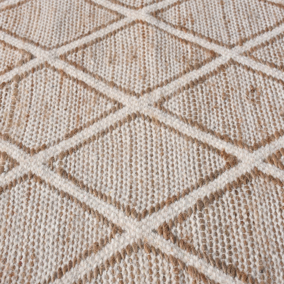 Chik handwoven wool and jute rug with a carved diamond lattice in ivory and natural, in a living room
