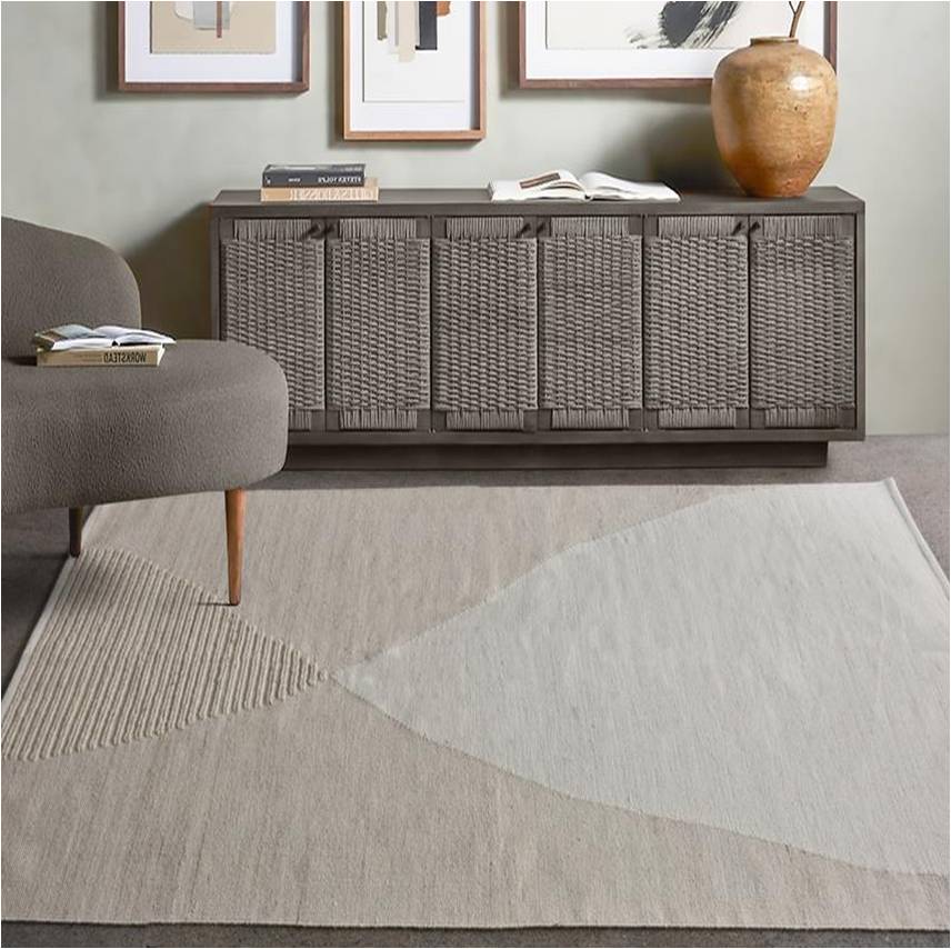 Kamaan handwoven wool flatweave rug with overlapping ivory and beige arcs, in a living room