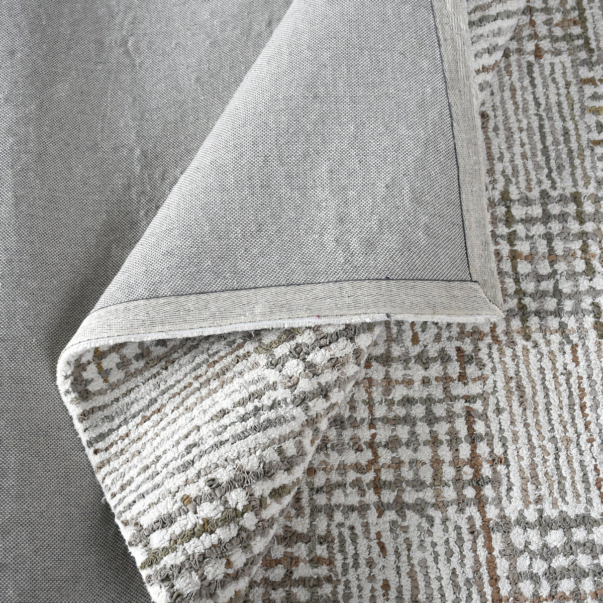 Tweed hand-tufted denim and cotton rug with fine grey and ivory check, in a bedroom