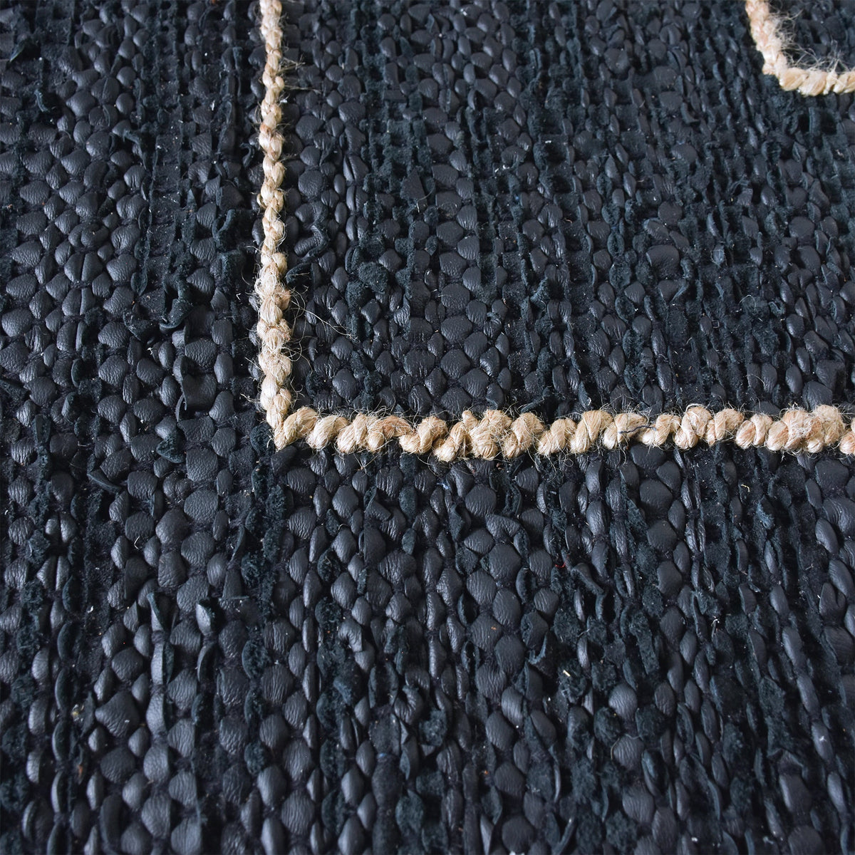 Aasmaan handwoven hemp and leather rug with cream nested angles on midnight navy, in a study