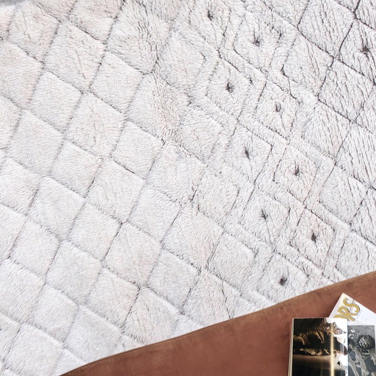 Til handwoven New Zealand wool flatweave rug with an ivory diamond lattice and dots, in a living room