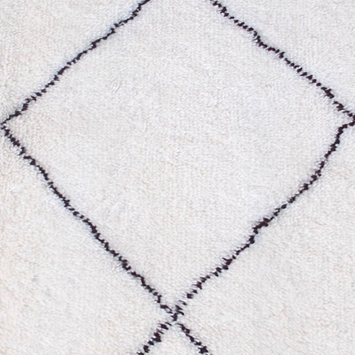 Snowfield handwoven wool rug with fine charcoal diamond lattice on ivory, in a study