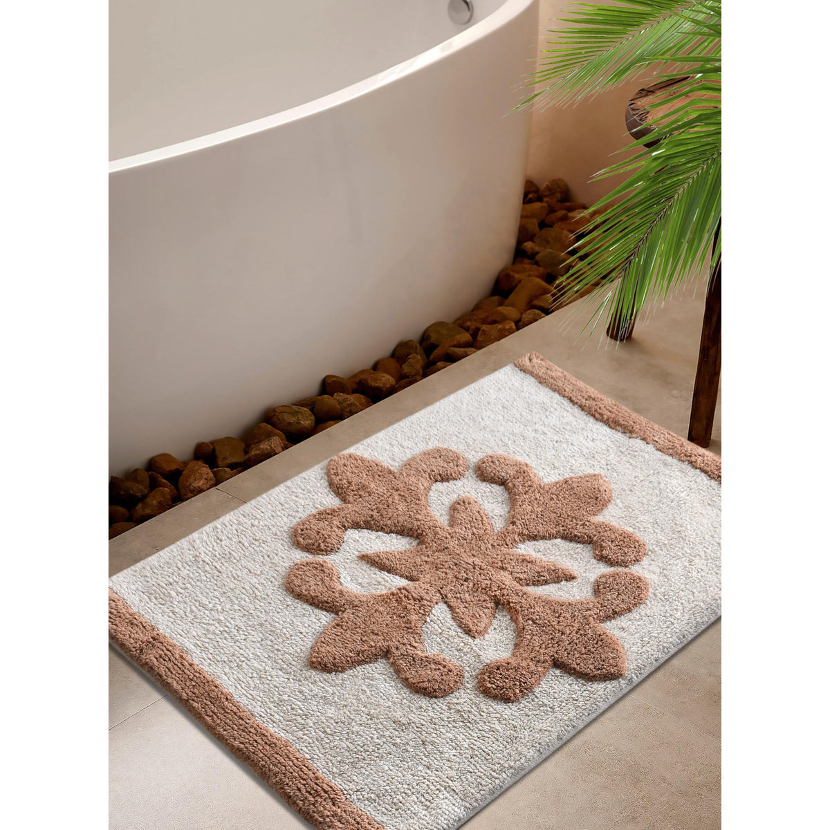 Sienna Bloom Cotton Bath Rug — A raised beige floral motif sits on an ivory ground.