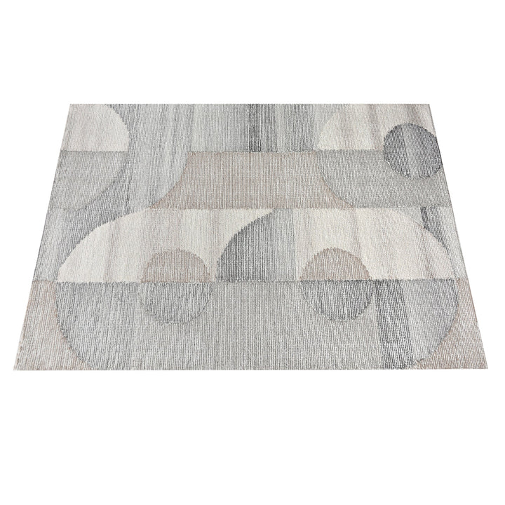 Ghera handwoven pale grey wool rug with overlapping cream circles, in a living room