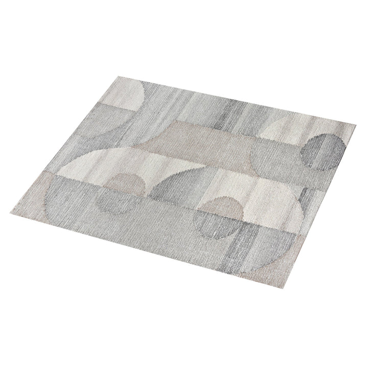 Ghera handwoven pale grey wool rug with overlapping cream circles, in a living room