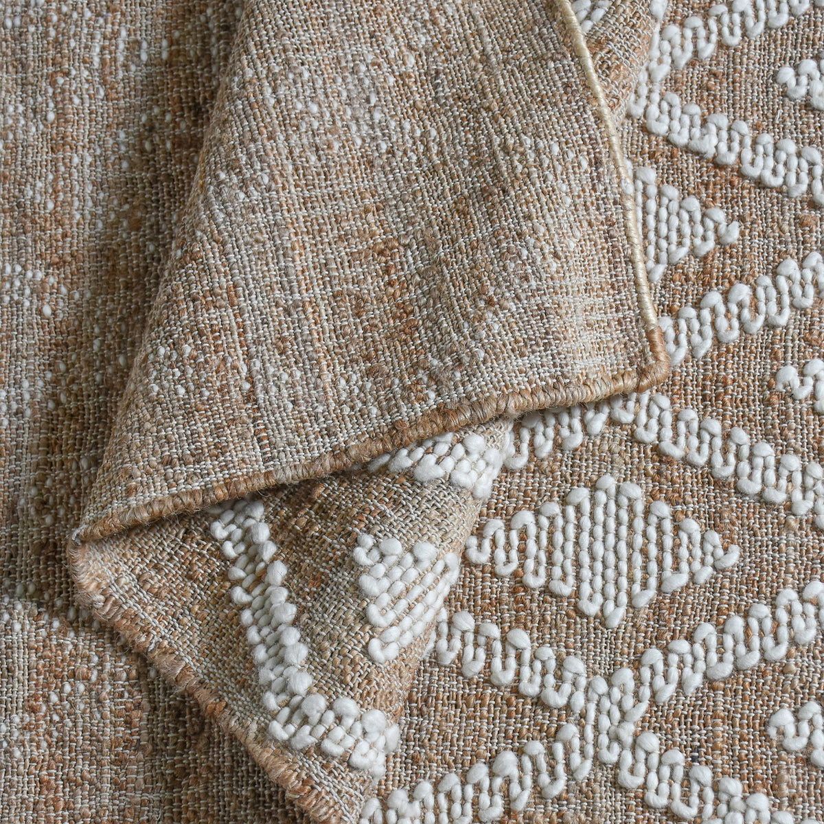 Thistle flatweave jute and wool rug with ivory tufted diamonds on taupe, in a living room