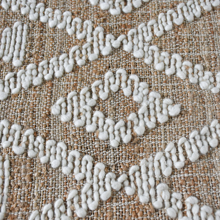 Thistle flatweave jute and wool rug with ivory tufted diamonds on taupe, in a living room