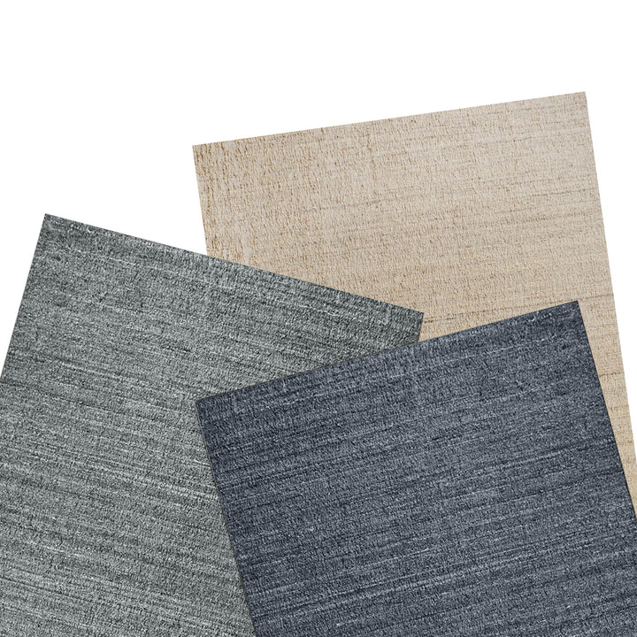 Saada handwoven flat wool rug in solid stone beige with charcoal, in a living room