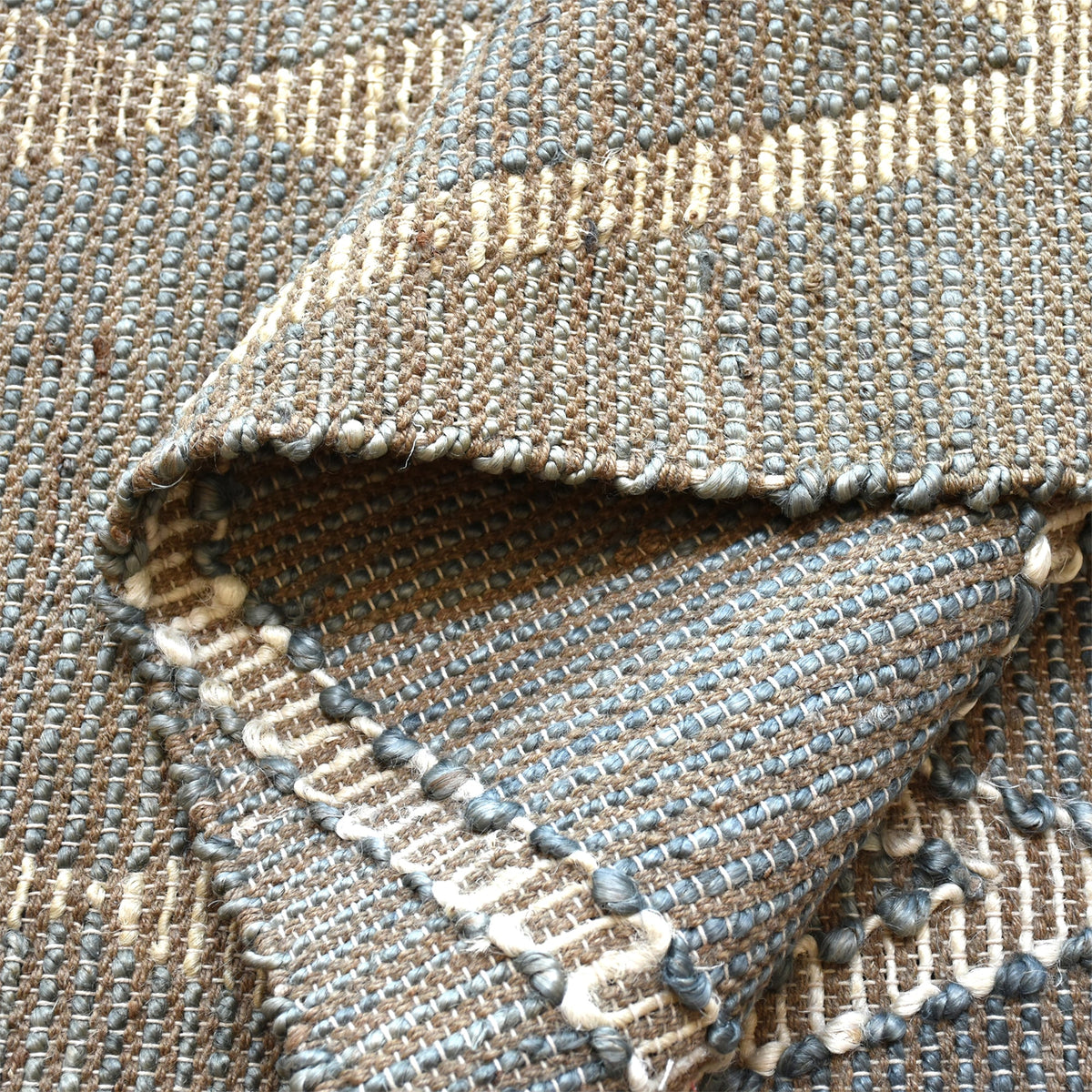 Thyme handwoven hemp rug with an ivory diamond lattice on sage grey, in a dining room