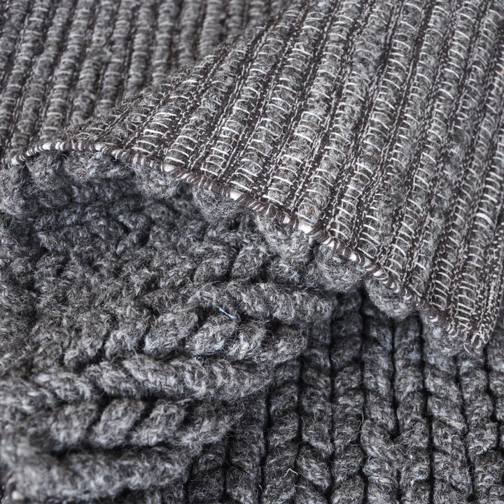 Dor handwoven chunky wool rug in charcoal, woven in thick cords, in a living room