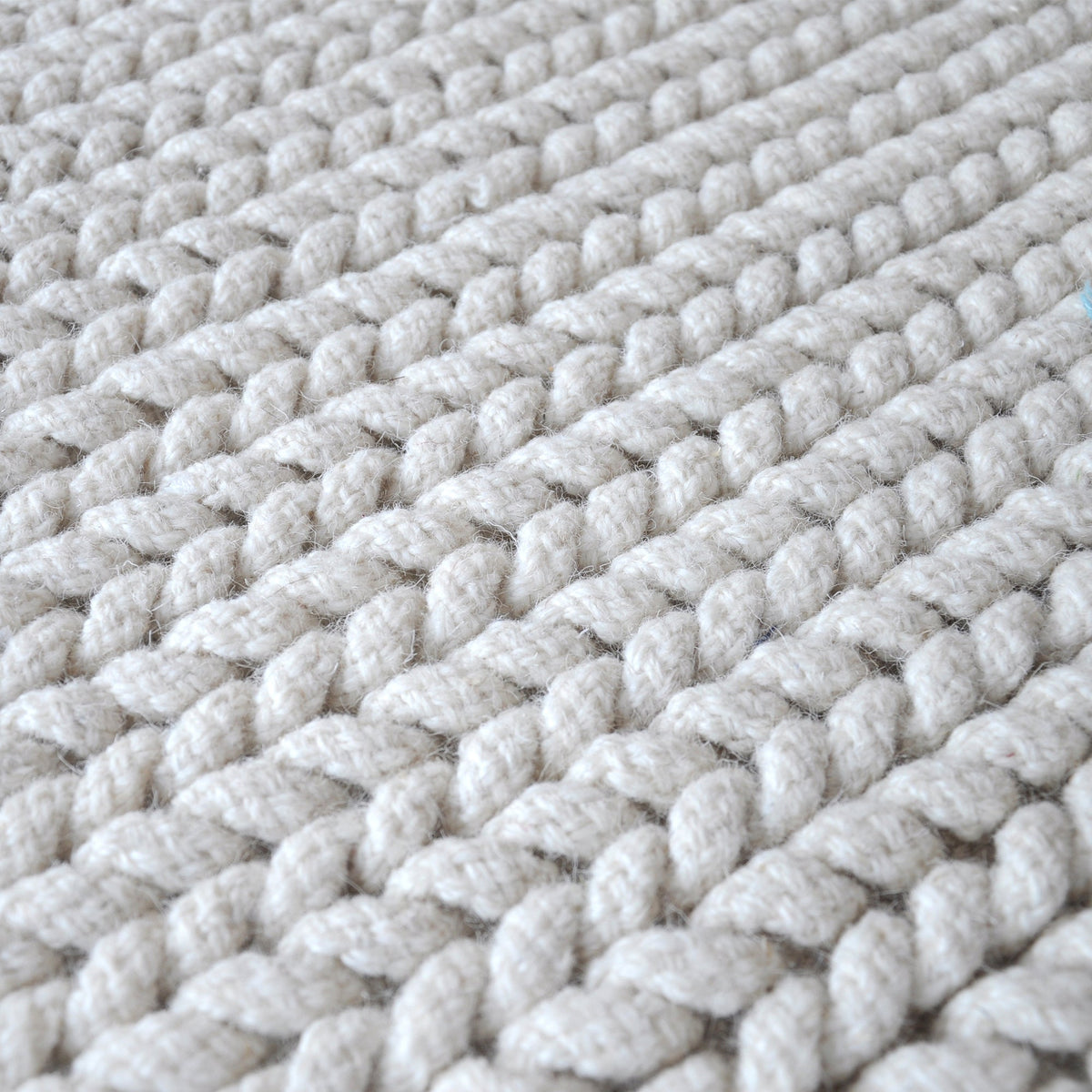 Dor handwoven chunky wool rug in charcoal, woven in thick cords, in a living room