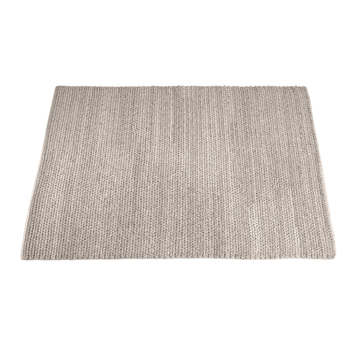 Dor handwoven chunky wool rug in charcoal, woven in thick cords, in a living room