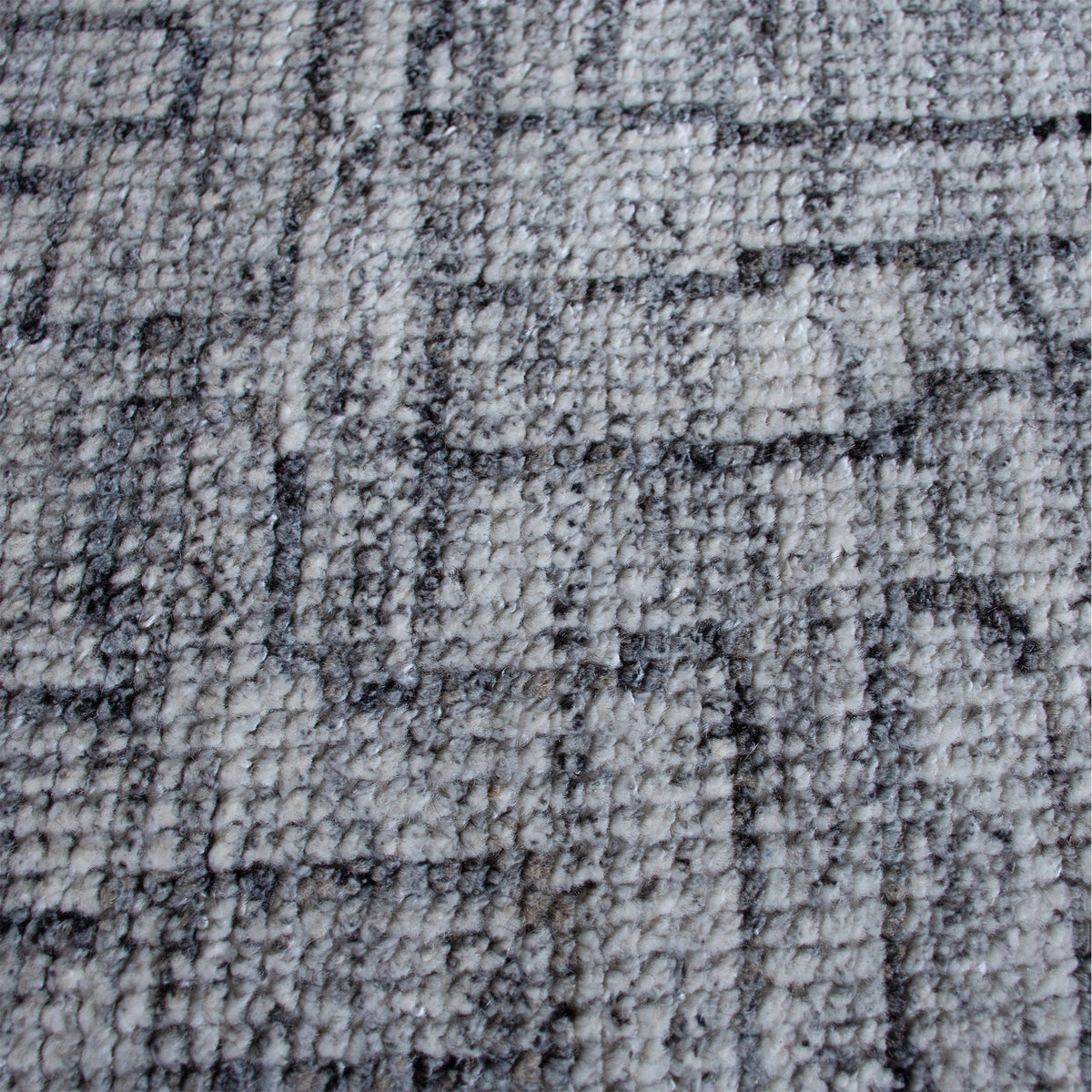 Barsaat hand-knotted wool and viscose rug with mottled blue-grey brick lines, in a living room