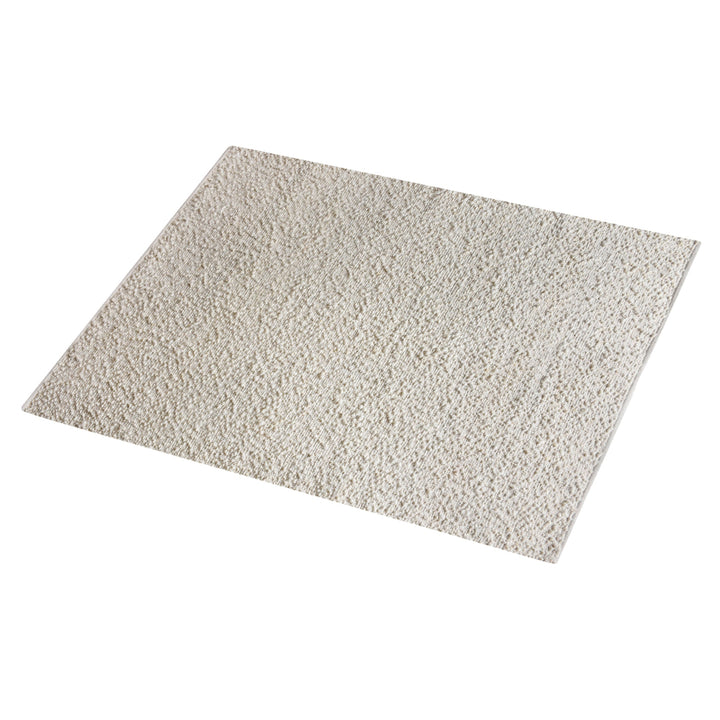 Lambswool handwoven ivory wool and jute rug with a bouclé pebble pile, in a living room