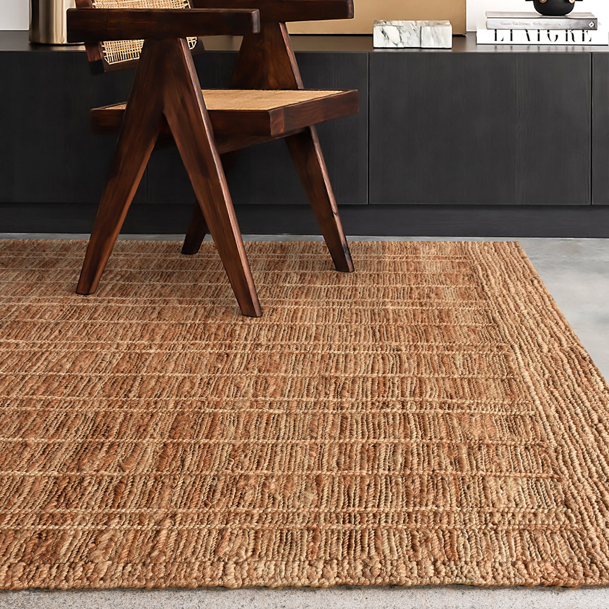 Geru hand-knotted jute rug in burnt sienna and tan with a rustic high pile, in a living room